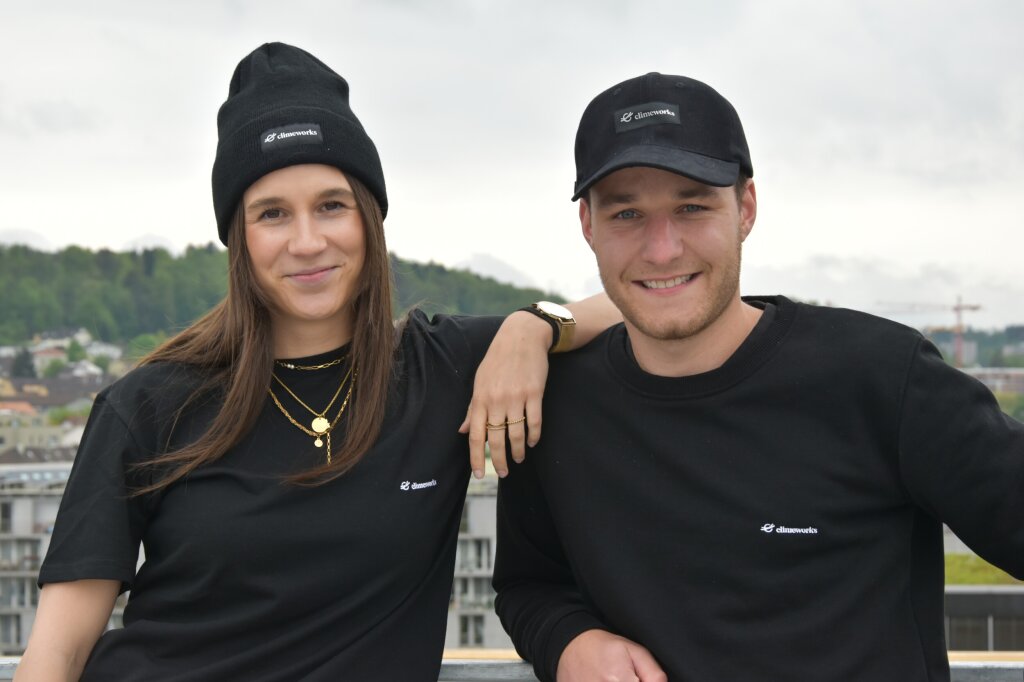 Two Climeworkers wearing Climeworks' branded merchandise